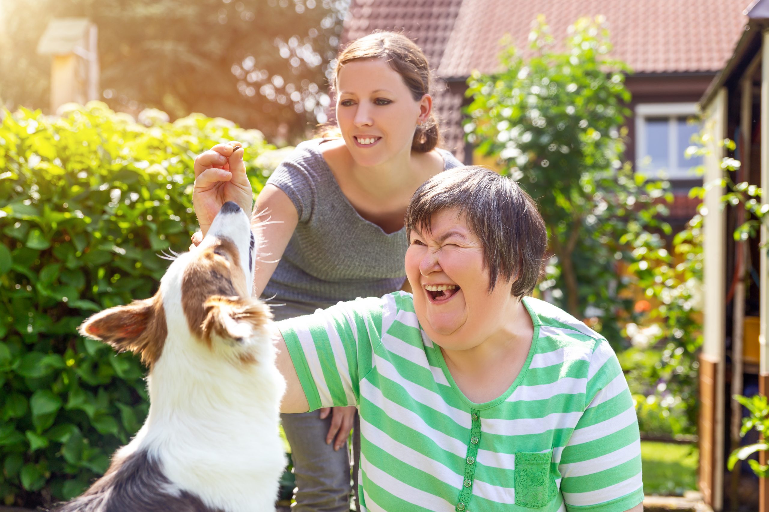 two ladies playing with dog
